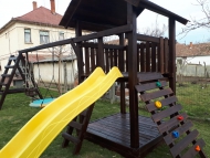 Óriás fatetős torony, mászó fallal, homokozó tetővel, hosszú rúddal, óriás mászókával, fészekhintával